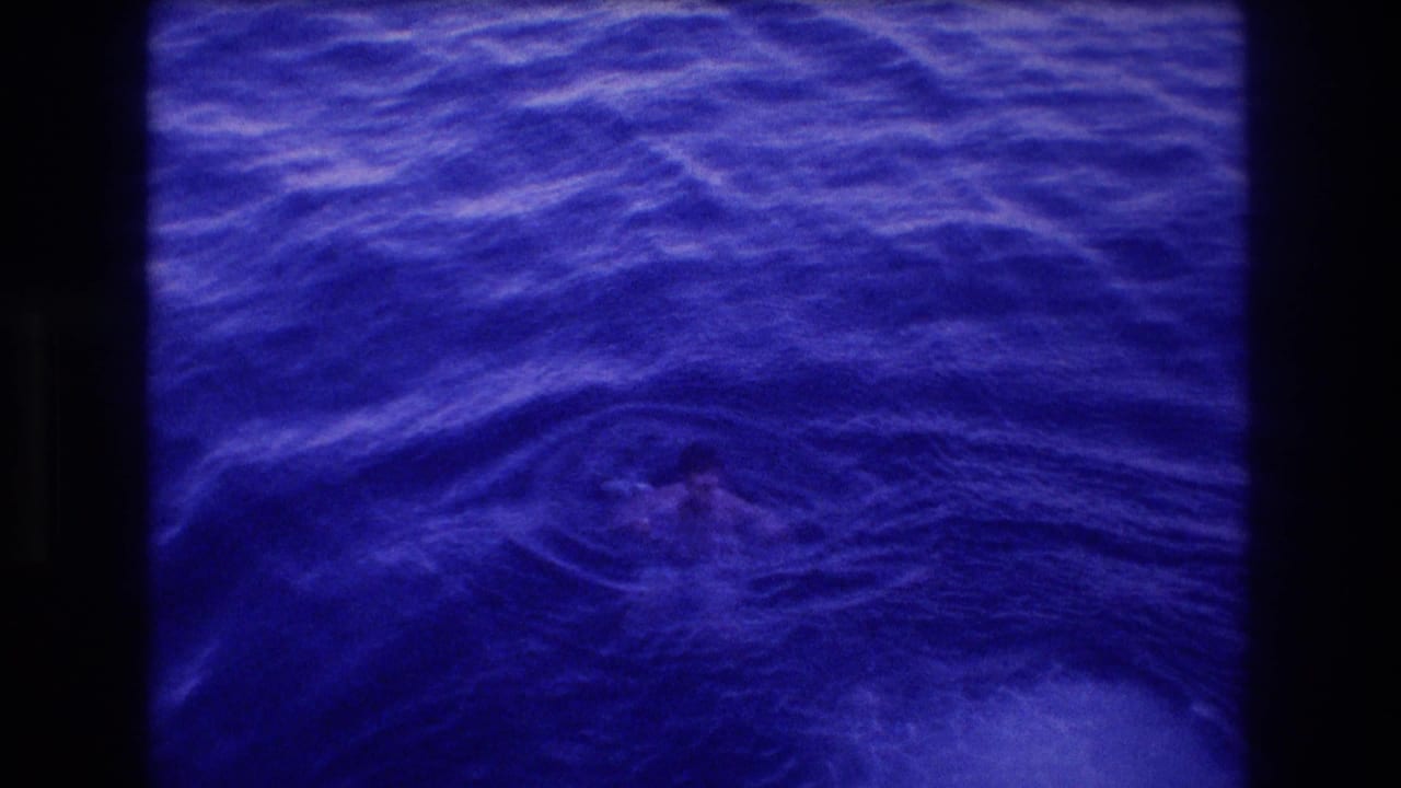 8mm home movie frame of churning blue-indigo ocean surface with a distant swimmer, from Acapulco Mexico 1982 dive sequence