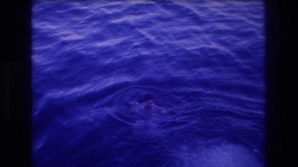 8mm home movie frame of churning blue-indigo ocean surface with a distant swimmer, from Acapulco Mexico 1982 dive sequence