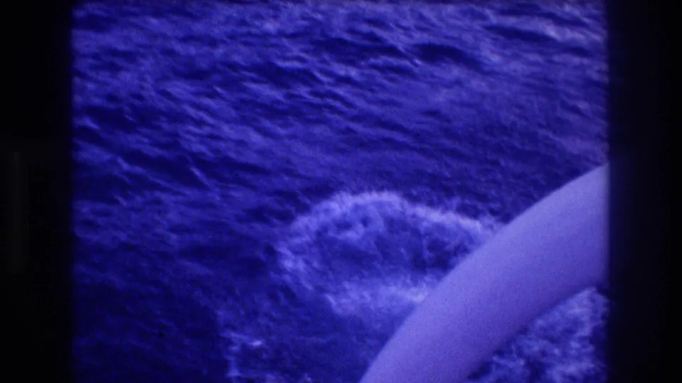 8mm footage of blue ocean water with the edge of a white platform or railing at lower right, from Acapulco Mexico 1982 dive sequence