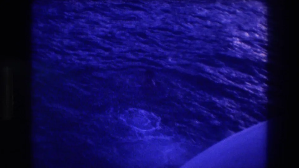 8mm home-movie frame of open ocean viewed from a moving boat, circa 1982 Acapulco; characteristic blue film-aging cast with visible grain.