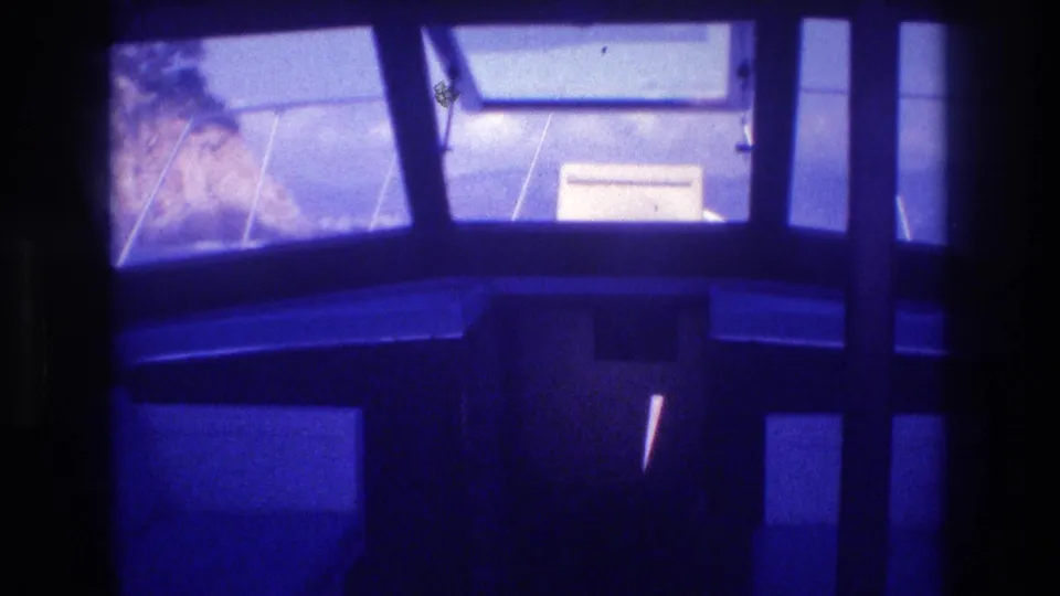 Boat cabin interior, possibly Acapulco, Mexico, 1982; rocky cliffs and a partially visible sign or notice through windows; pronounced blue-violet 8mm color shift.