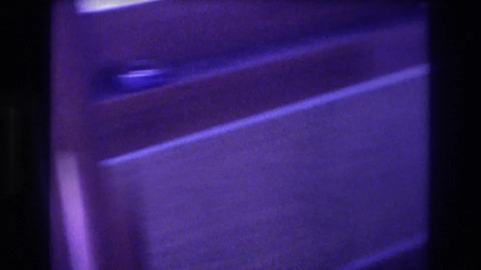 8mm close-up of speedboat interior woodwork and a metal latch or handle with blue-purple film shift, consistent with Acapulco 1982 home-movie footage.