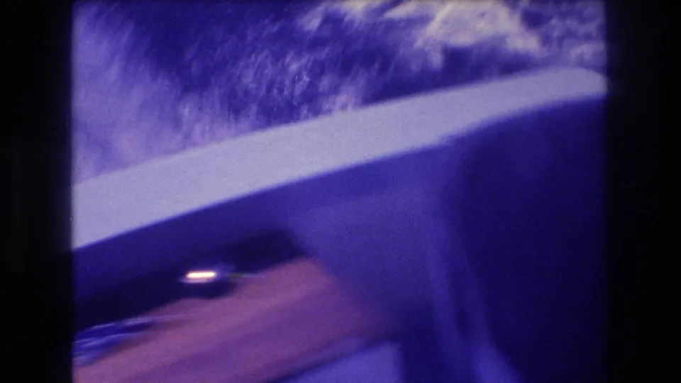 8mm motion-blurred speedboat interior with white window trim, wood panel, and partial view of a passenger's head, Acapulco 1982.