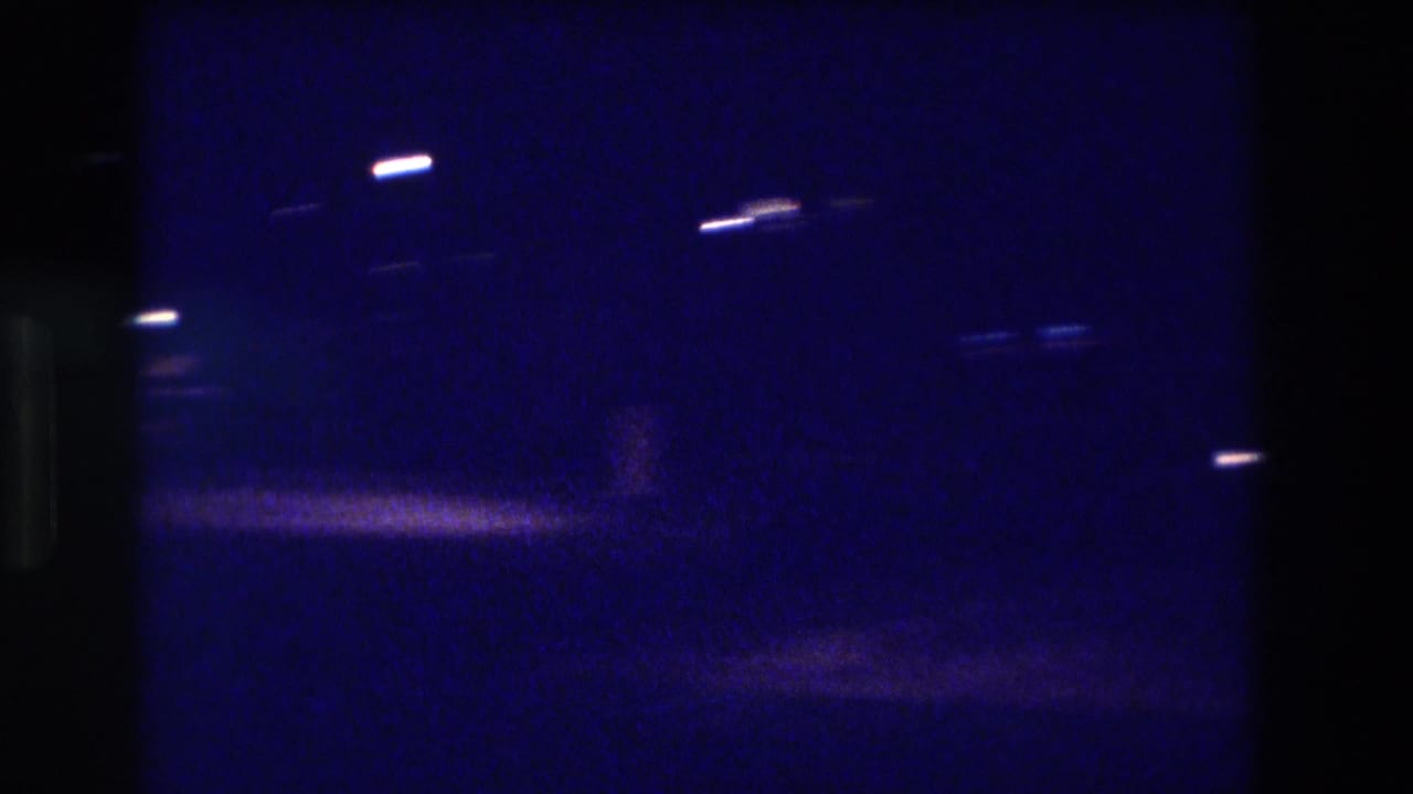 Night exterior on 8mm film, ca. 1982, showing sparse scattered lights in deep blue tones; location stated as Acapulco, Mexico.