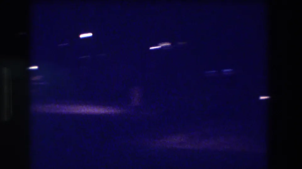 Night exterior on 8mm film, ca. 1982, showing sparse scattered lights in deep blue tones; location stated as Acapulco, Mexico.