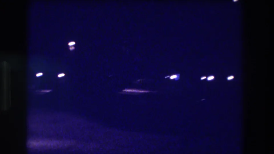 8mm night footage from what metadata identifies as Acapulco, Mexico, 1982, showing a street lamp and distant lights across an open dark area.