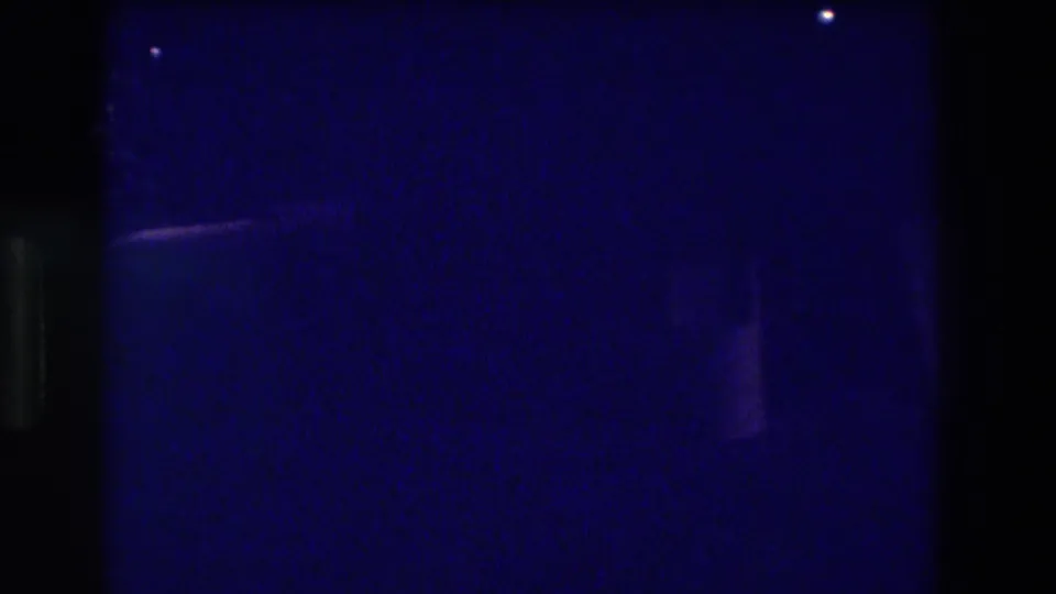 Extremely dark 8mm exposure during nighttime filming in Acapulco, Mexico, 1982, with almost no discernible subject detail visible.