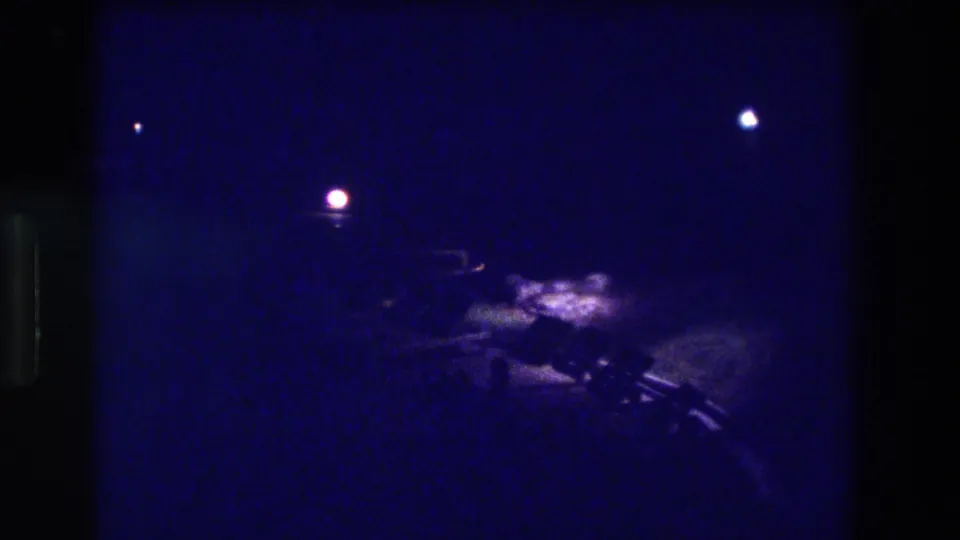 8mm night pan, Acapulco Mexico 1982—two visible light sources and blurry low shapes that may be street-level objects or ground-level forms.