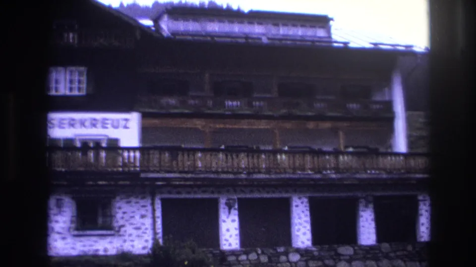 Final frame of Mooserkreuz alpine hotel pan, 1967 — sign partially cropped, with a film flare at right edge characteristic of 8mm home movie footage.