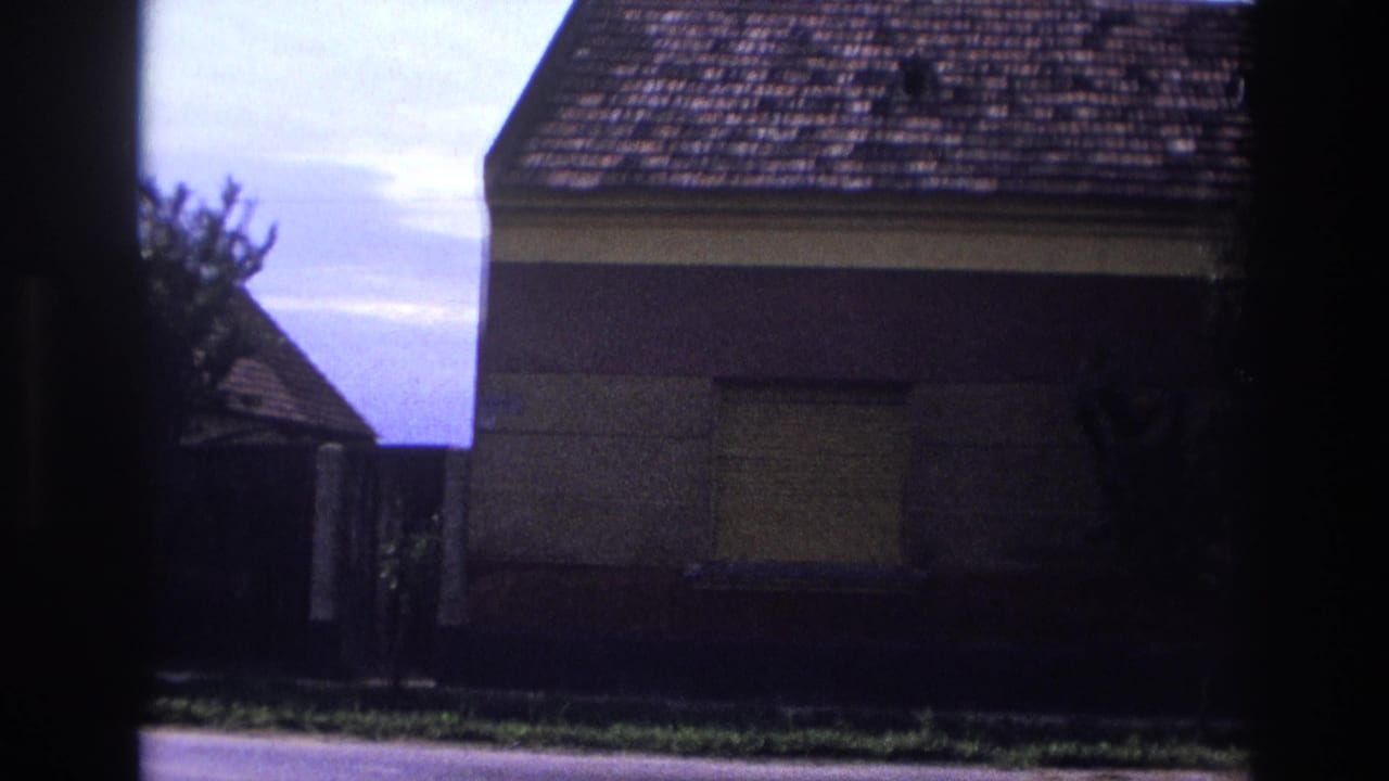 Similar view of a shuttered house and roadside with dark frame borders.