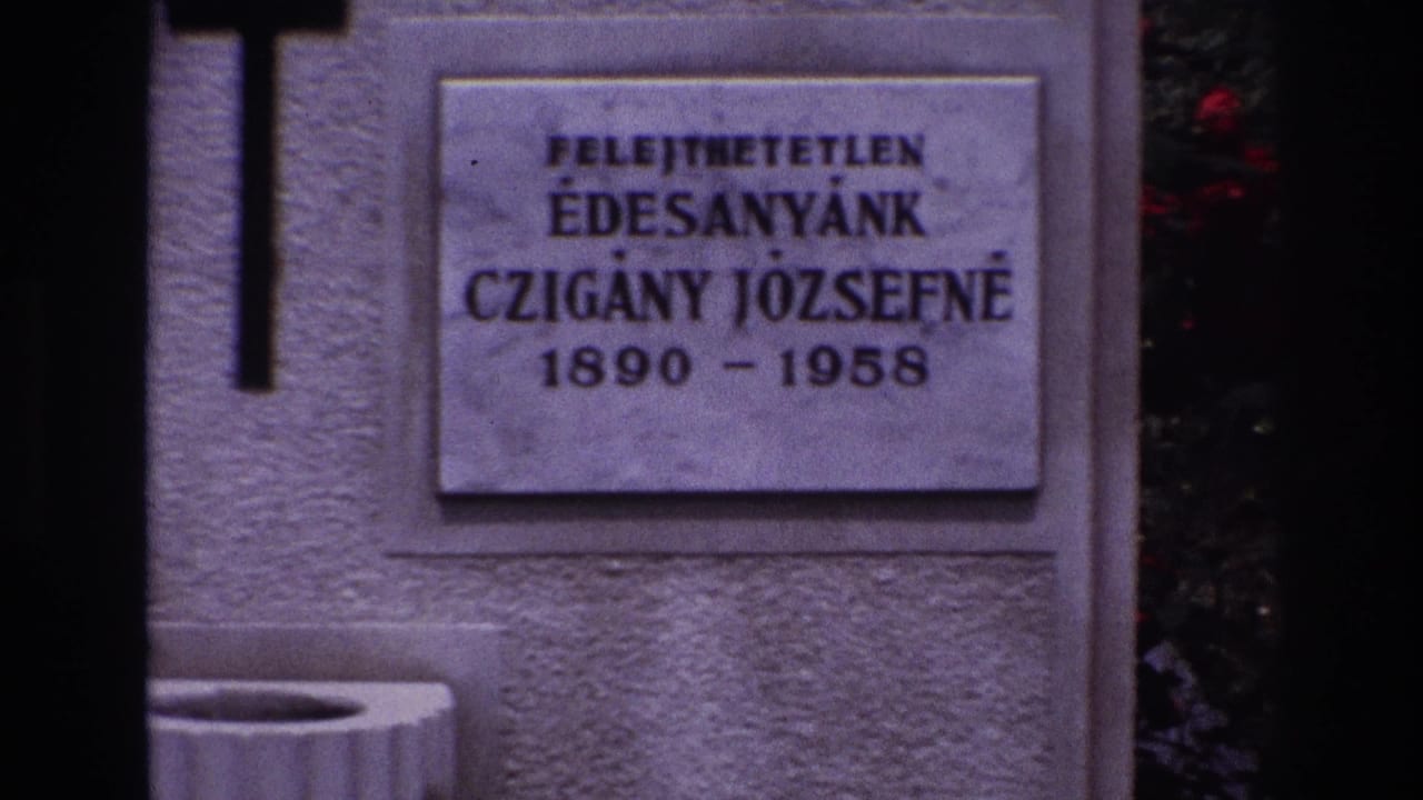 Close view of a stone grave marker with black cross and Hungarian inscription dated 1890-1958.