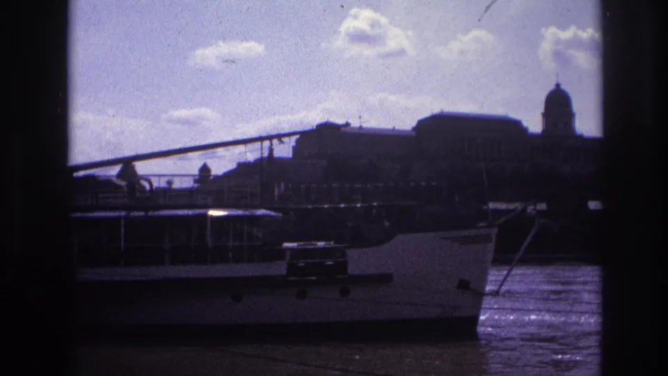 1967 France 8mm frame with the riverboat bow in the foreground and a domed waterfront building visible across the water.