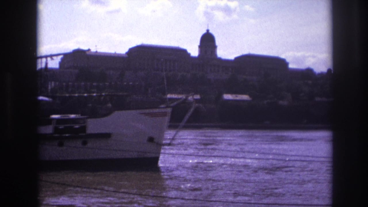 Riverboat bow near the center with a domed building silhouetted on the far bank.