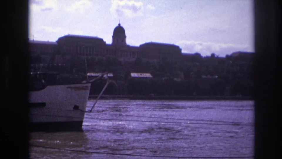 1967 France 8mm frame with the riverboat moving out of view and a domed historic building across the water.