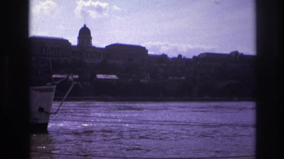 1967 France home-movie frame of a boat edge at left with a broad river and domed waterfront architecture beyond.