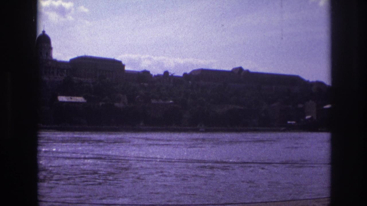 River and silhouetted hillside buildings framed by dark borders, with a dome at left.