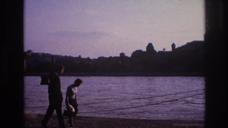 At the end of the 1967 France clip, the couple walks rightward by the lake under soft light and heavy shadow borders.