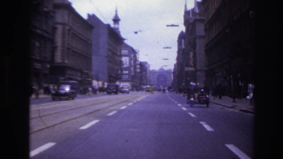 The final 1967 France street frame shows a broad road, tram rails, older cars, pedestrians, and the sidecar motorcycle receding ahead.