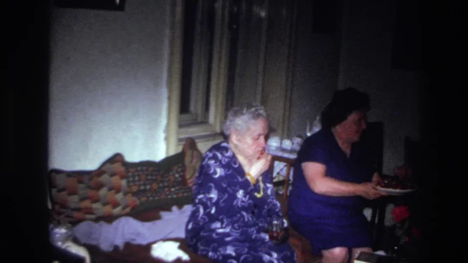 A 1967 France domestic frame shows an older woman eating fruit while a younger woman in blue moves the plate across the room.