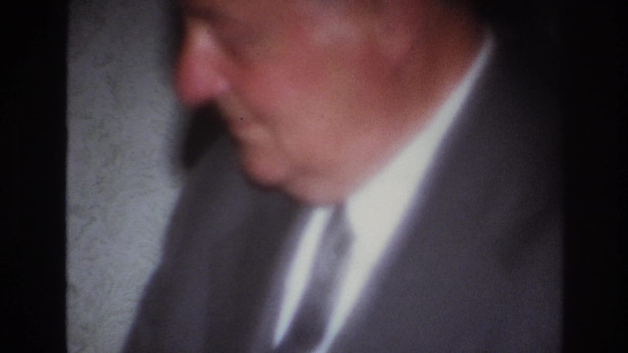 Soft close-up of a suited man turned partly to the side.