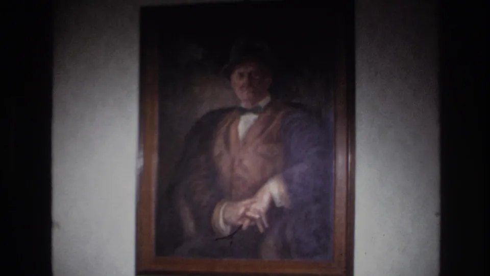 Closer 1967 France 8mm view of the portrait, revealing the painted man's hat, bow tie, vest, jacket, and hands.
