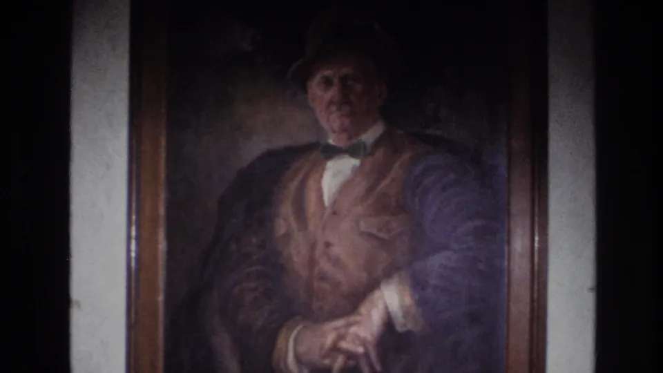 1967 France 8mm close view of a framed painted gentleman in a hat, bow tie, vest, and dark jacket.