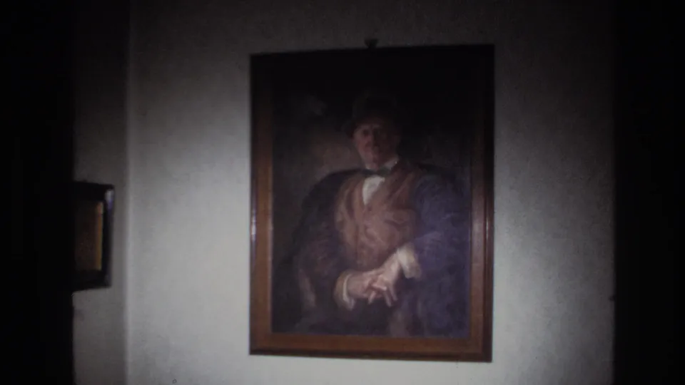 1967 France 8mm frame at the widest view, showing the portrait centered on a plain wall inside a dim room.
