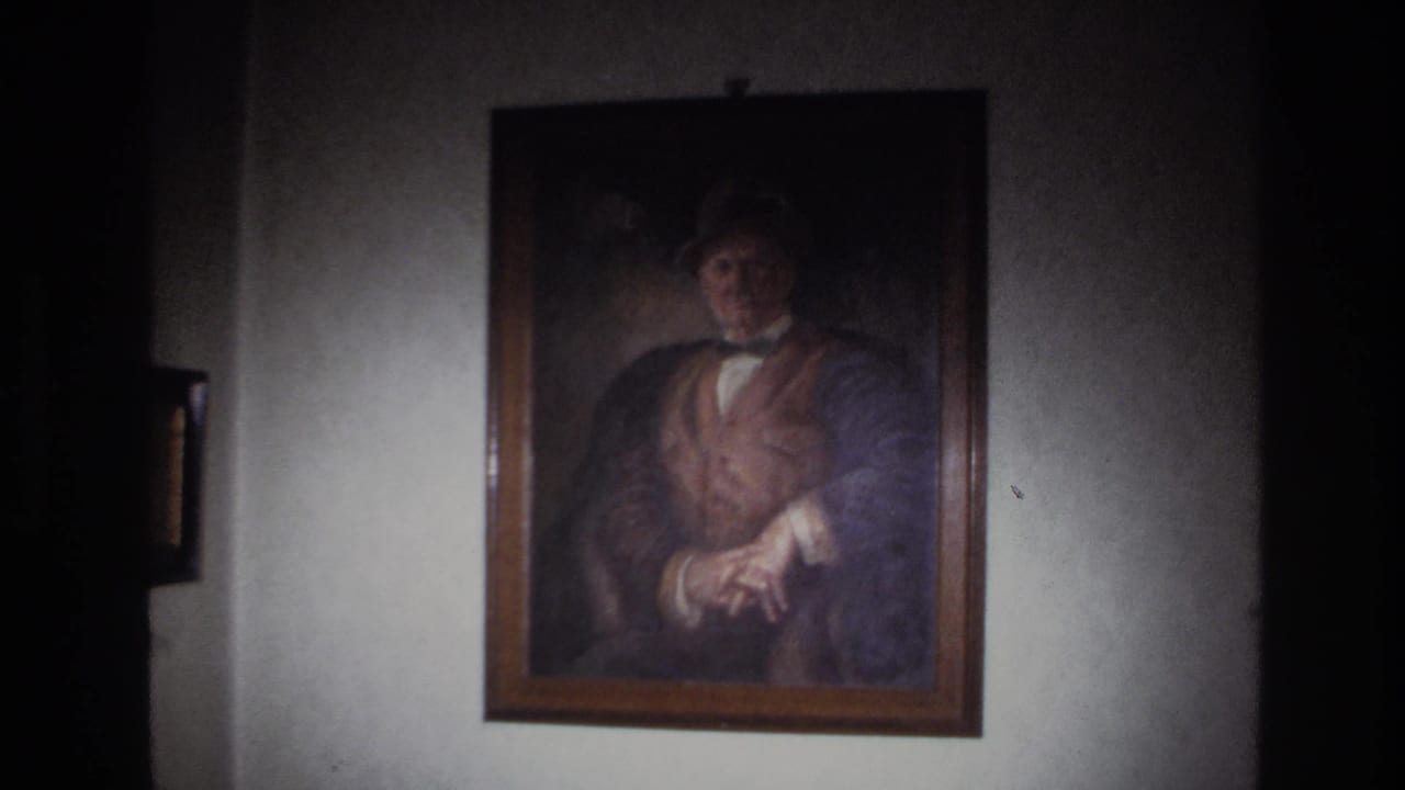 1967 France 8mm frame showing a framed portrait on a wall inside a dim private interior.