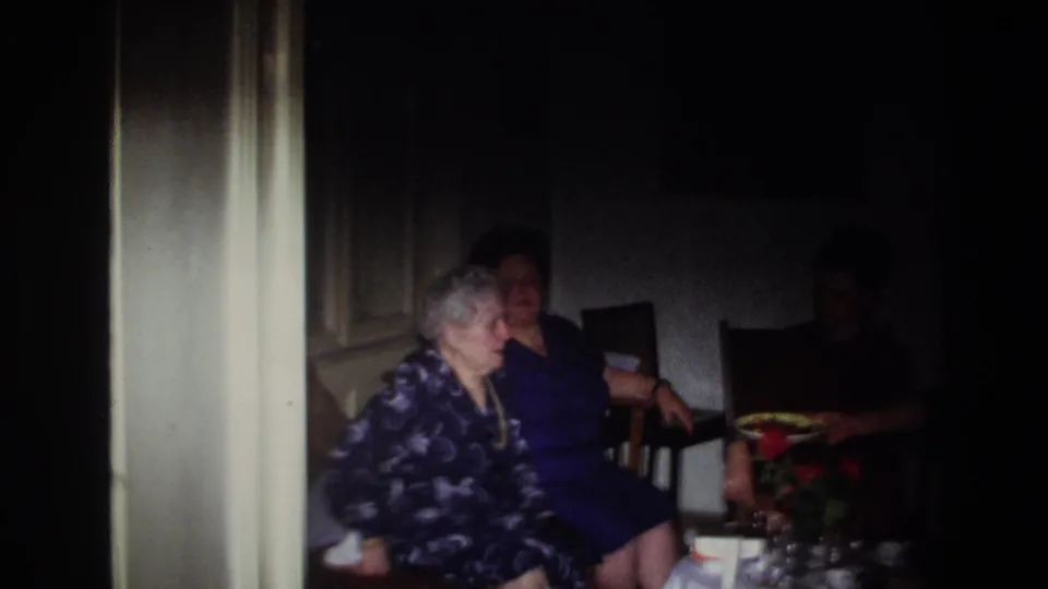 1967 France home interior with two women clearly seated on the left and a third woman partly obscured in shadow by the tea table.