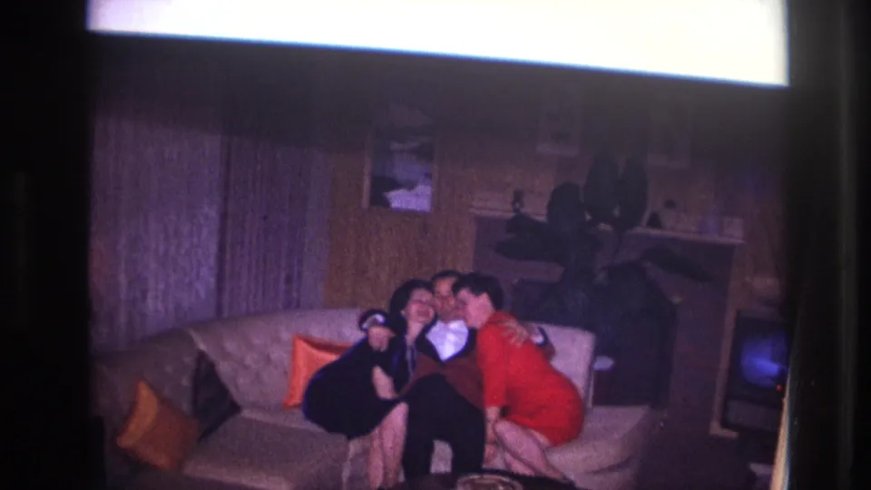 In the final frame, the three adults embrace on the sofa in the softly exposed 1967 Ottawa home interior.