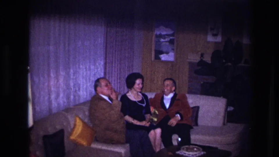 The group appears relaxed and smiling on the sofa in the supported 1967 Ottawa living-room footage, with wood paneling behind them.