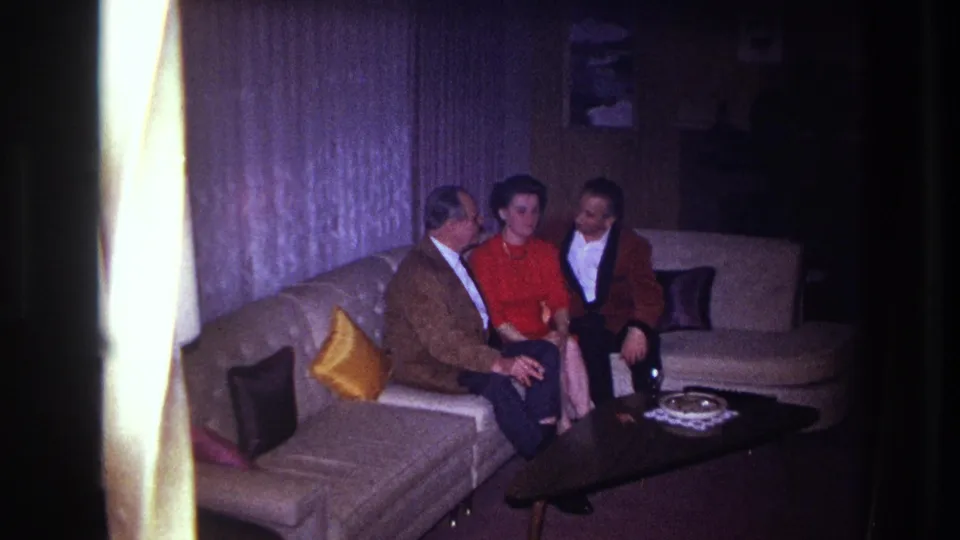 The final frame shows three adults seated in a 1967 Ottawa living room with a sectional sofa, lamp, curtains, pillows, and coffee table.