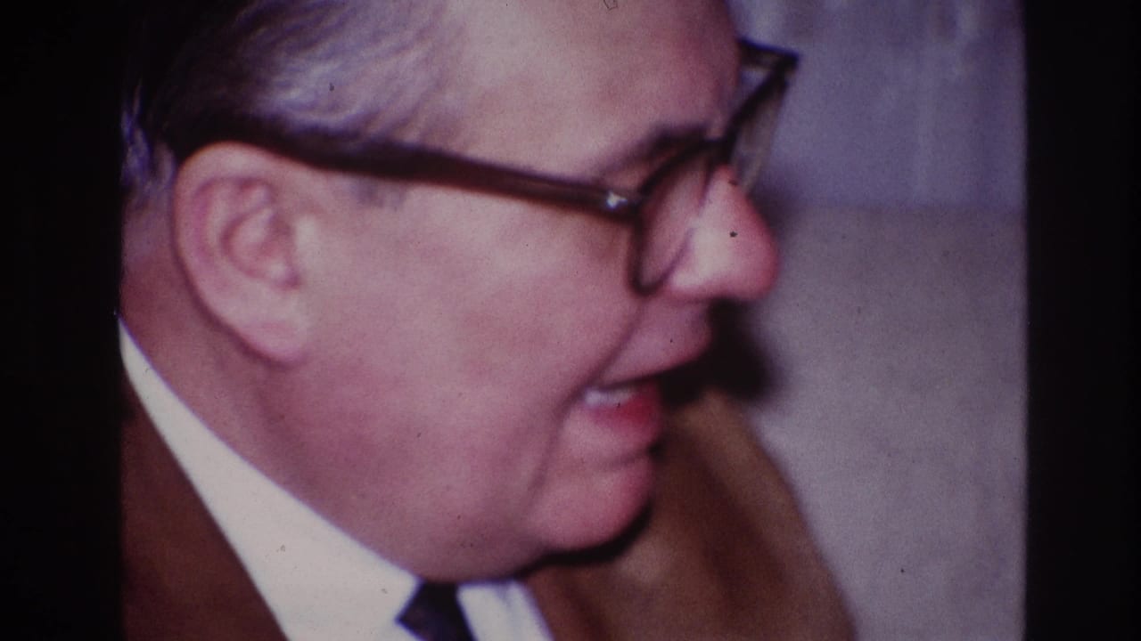 Man in glasses shown in close side profile with mouth open as he talks.