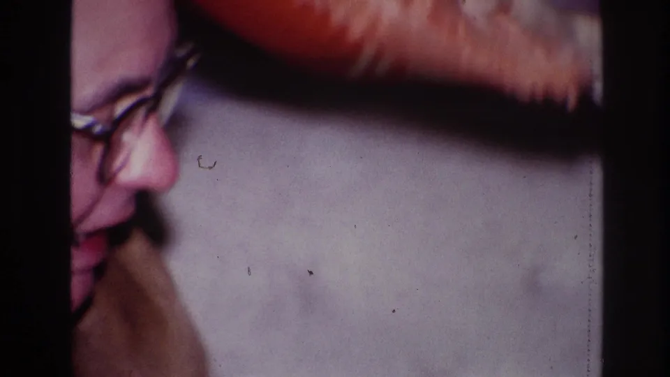 The final frame partly crops the man's profile while a blurred arm or hand passes near the top of the indoor 1967 Ottawa scene.