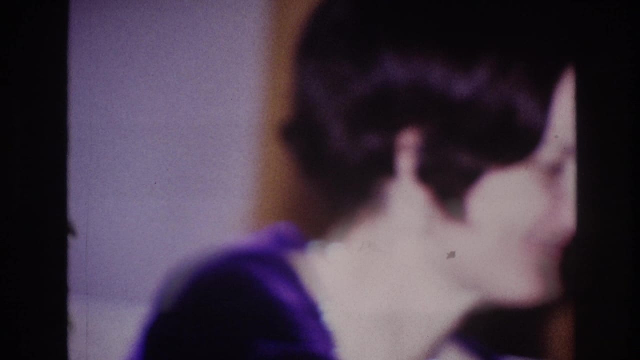 1967 Ottawa party frame showing the woman from behind and side, her short dark hair and dark top visible in warm interior light.