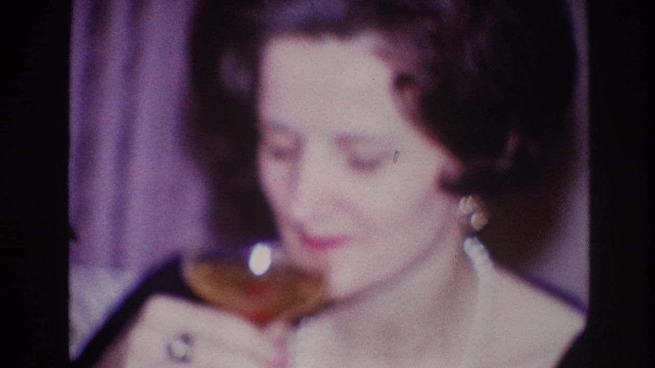 Soft 8mm footage shows the Ottawa woman smiling with a drink glass, pearl necklace, earrings, and ring visible.