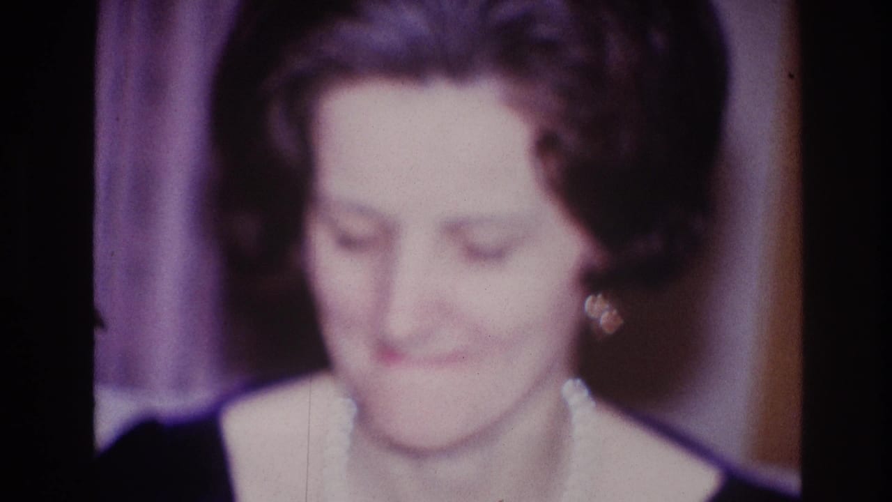 A woman in pearl jewelry appears to purse her lips while seated or standing in a private Ottawa interior in 1967 footage.