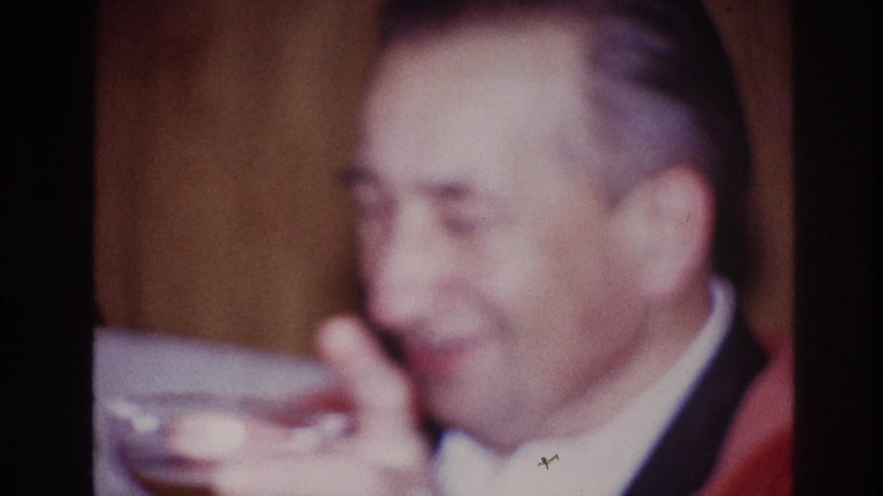 In Ottawa 1967 home-movie footage, an older man in a red jacket smiles as a cocktail glass enters the foreground.
