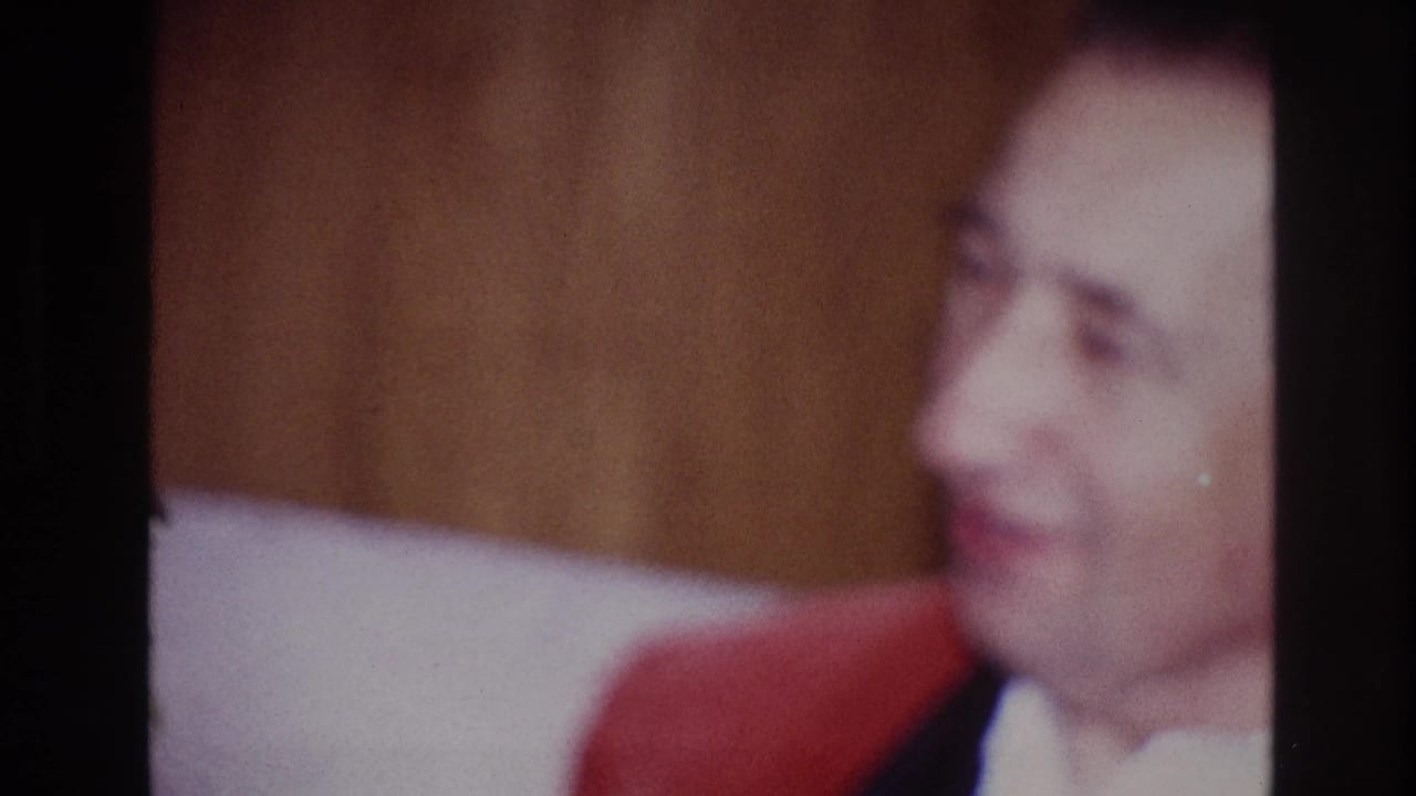 The man remains seated in the private Ottawa interior, turned slightly and softly lit after the affectionate exchange.