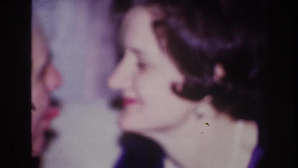 The woman turns in profile near another visible face, suggesting a close personal exchange during the 1967 Ottawa ceremony.