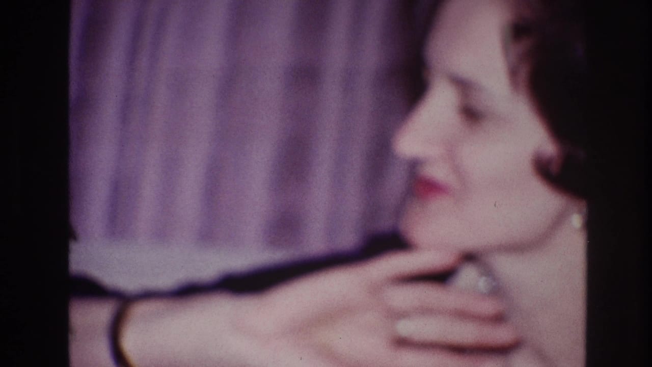Adult woman in profile touching her neck beside a purple curtain backdrop.