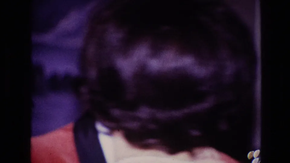 The final frame shows a close view of dark hair and the red-jacketed man during the affectionate 1967 Ottawa scene.