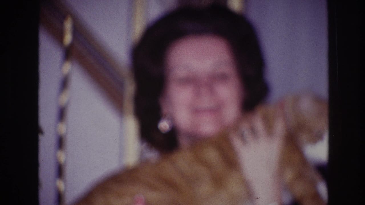 Woman in a dark top faces the camera while holding a ginger-and-white cat in 1967 Ottawa home-movie footage.