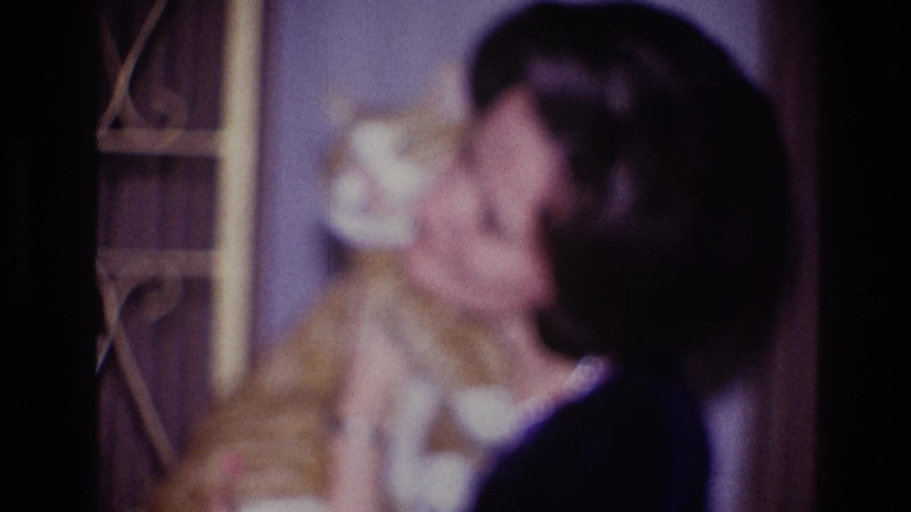 A 1967 Ottawa home-movie frame shows the woman holding the orange and white cat close as she kisses or nuzzles it.