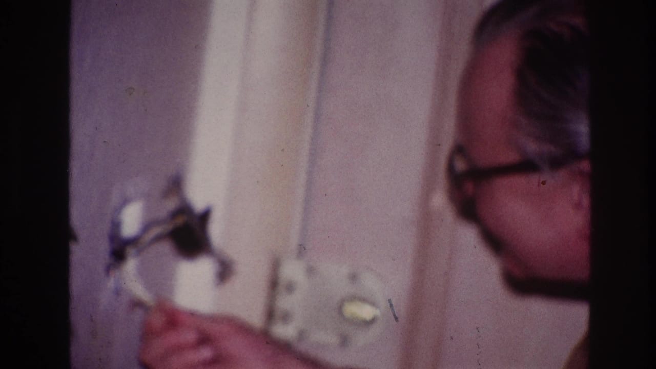 Close side view of a man looking at a wall fixture.
