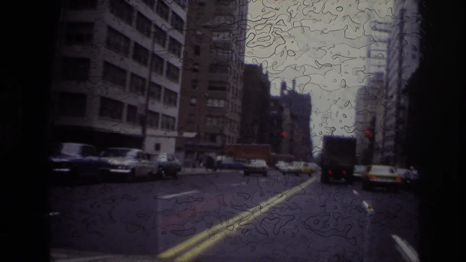 Moving-vehicle view of an Ottawa city street with parked cars, taller buildings, and an overcast sky.