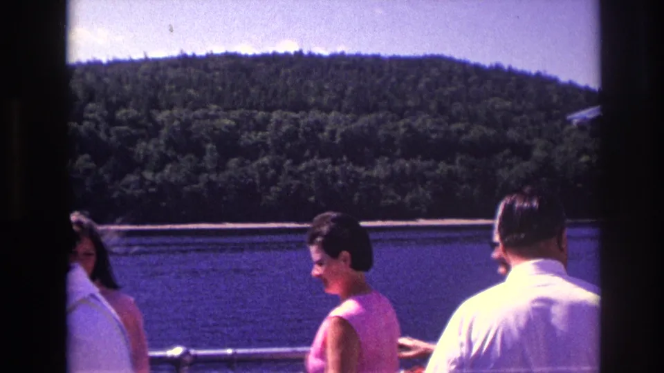 1967 Ottawa frame showing passengers on a boat, including a woman in a pink sleeveless dress and a man in a white shirt.