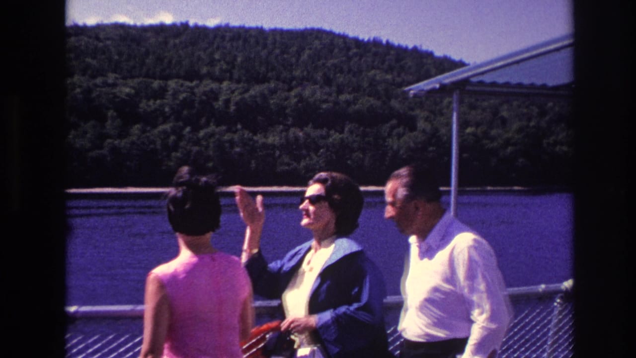 1967 Ottawa frame of a woman in sunglasses gesturing toward the scenery as adults stand near a riverboat railing.
