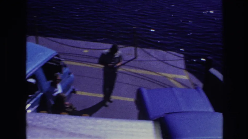 1967 Ottawa ferry scene with passengers near a blue van on deck, viewed from above with water visible behind them.