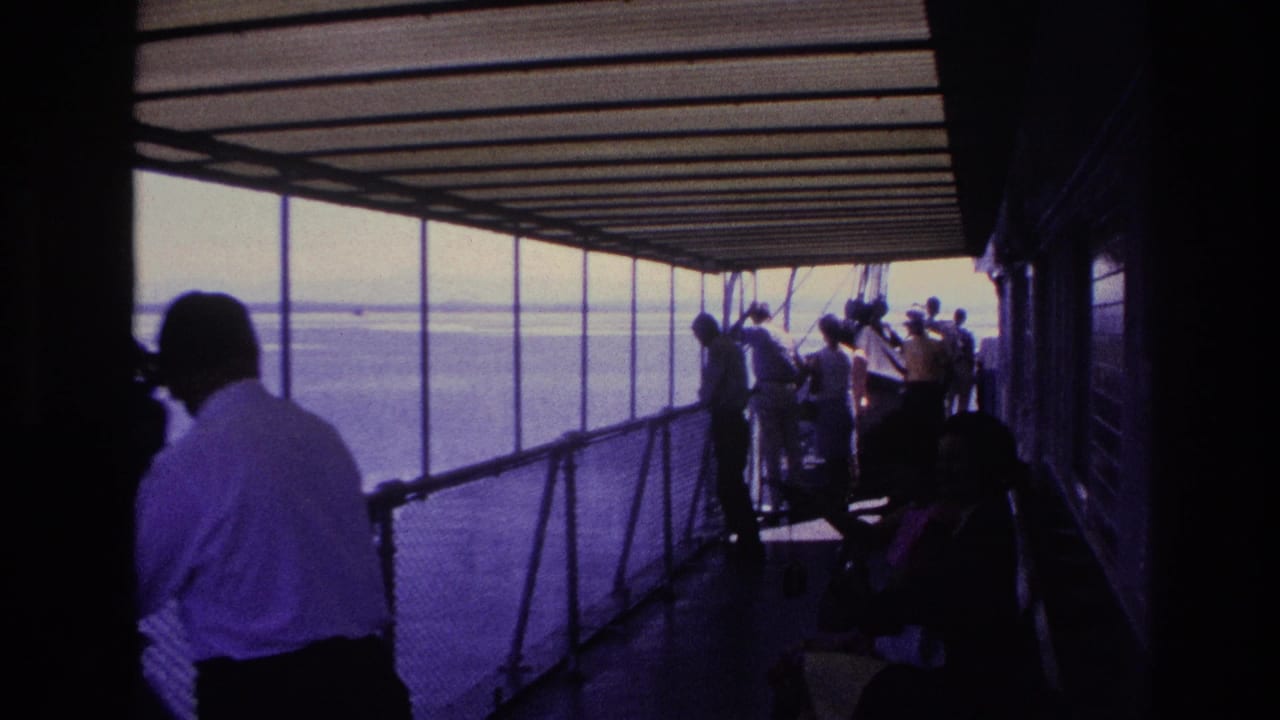Passengers on a covered boat deck in the supplied 1967 Ottawa footage look toward the water under a corrugated roof.